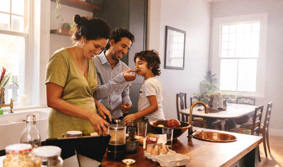 Image of family in kitchen and taste testing dinner