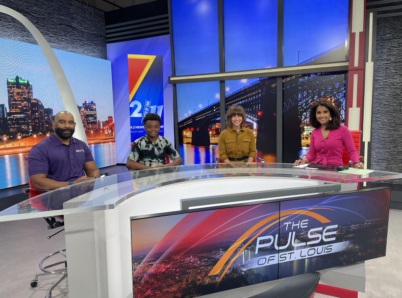 Image of Spire employee, student, principal and news anchor sitting at news desk in TV station