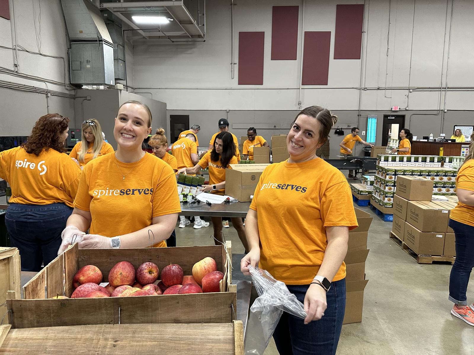 spire volunteers smiling while packaging food
