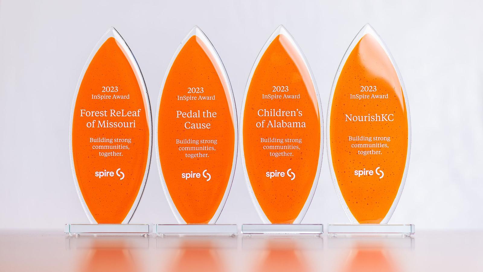 Image of four orange trophies on a white background