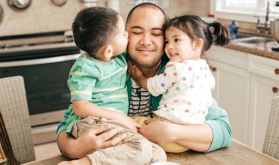 Dad hugging son and daughter