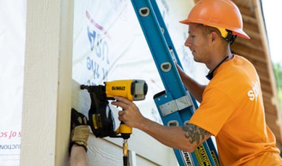 Image of Spire employee drilling at volunteer site