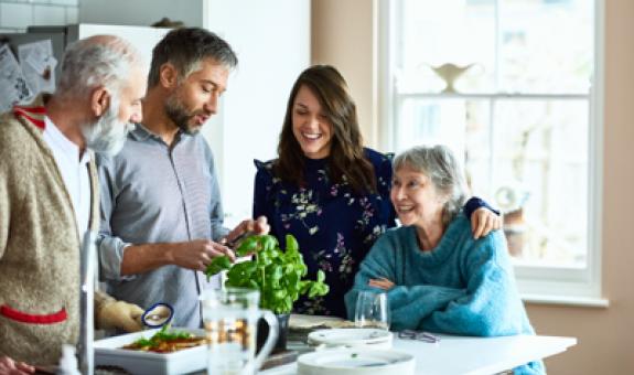 Image of family with multiple generations cooking around a table