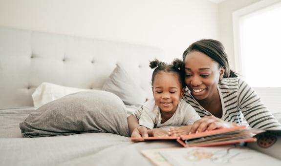 Image of mother and daughter reading a book together