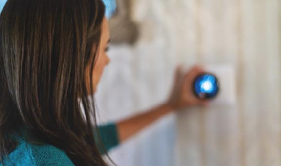Image of woman adjusting a smart thermostat