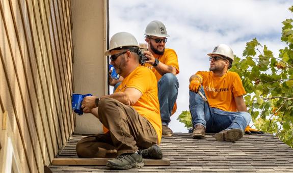 spire volunteers working on a roof