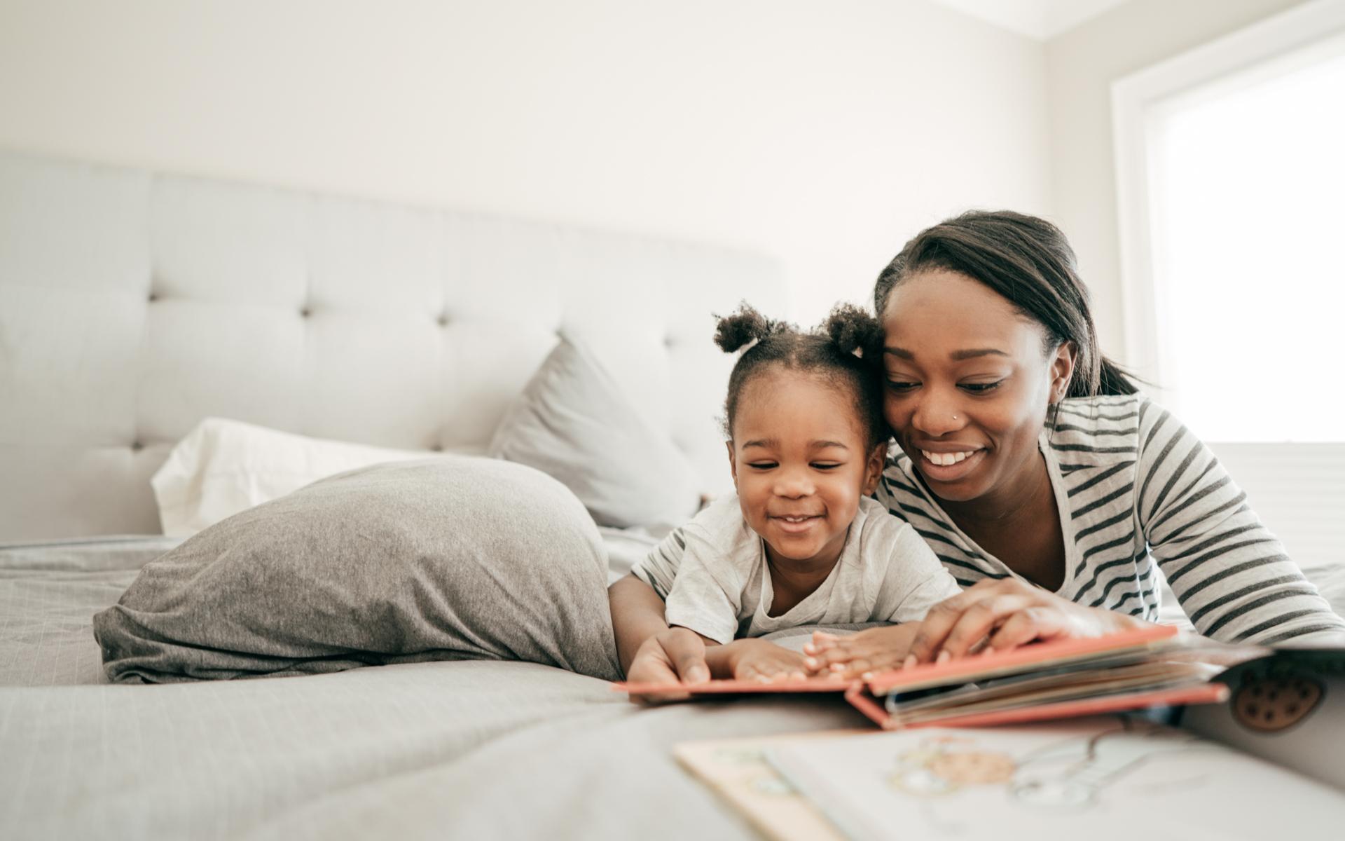 Image of mother and daughter reading a book together