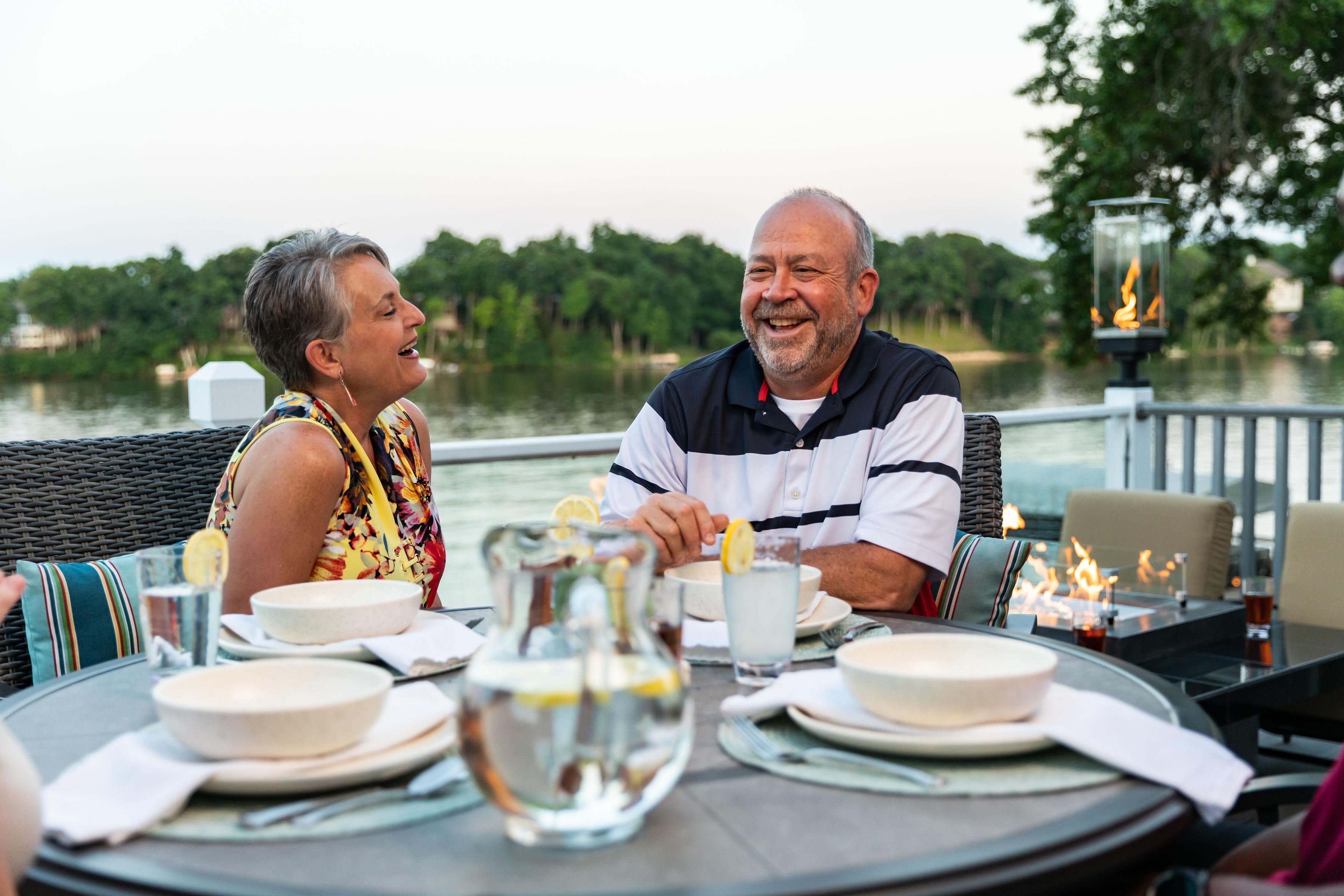 a couple laughing on their outdoor patio