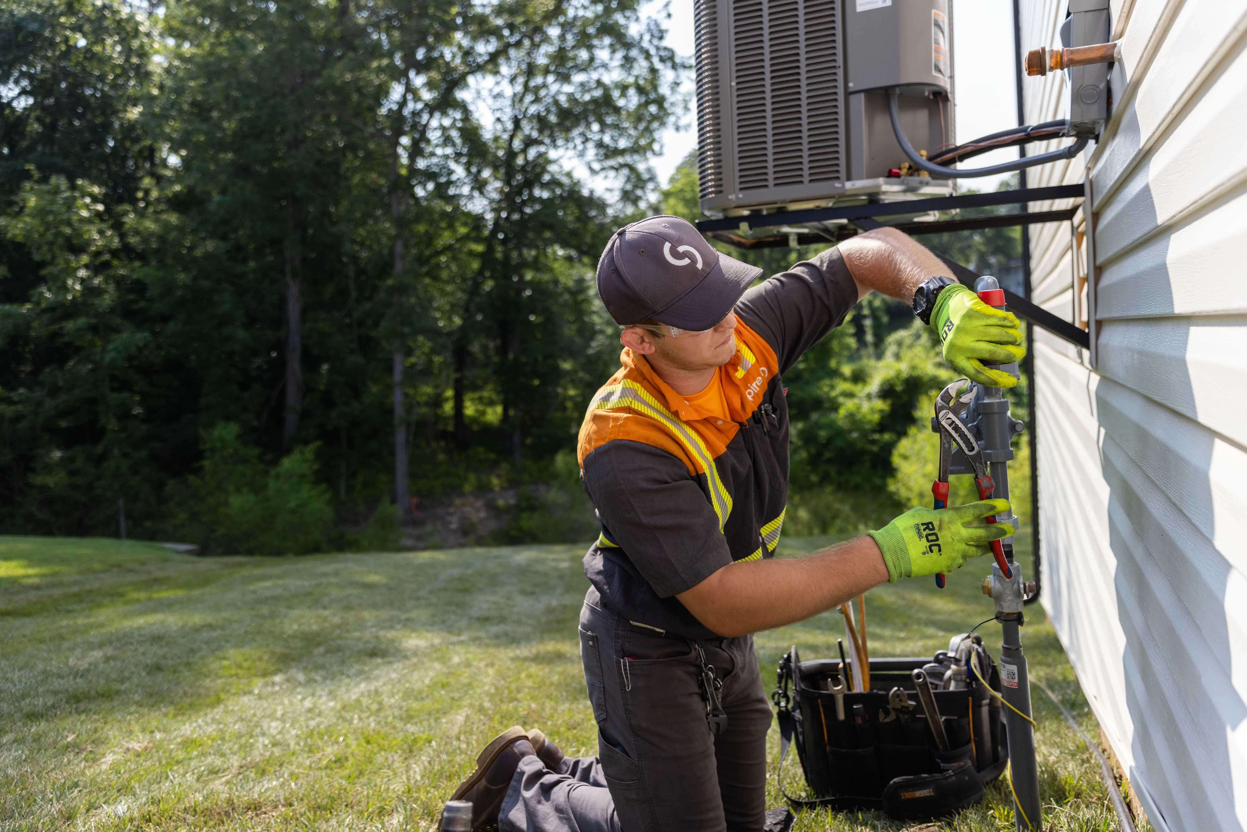Image of Spire employee installing a meter on the outside of a home