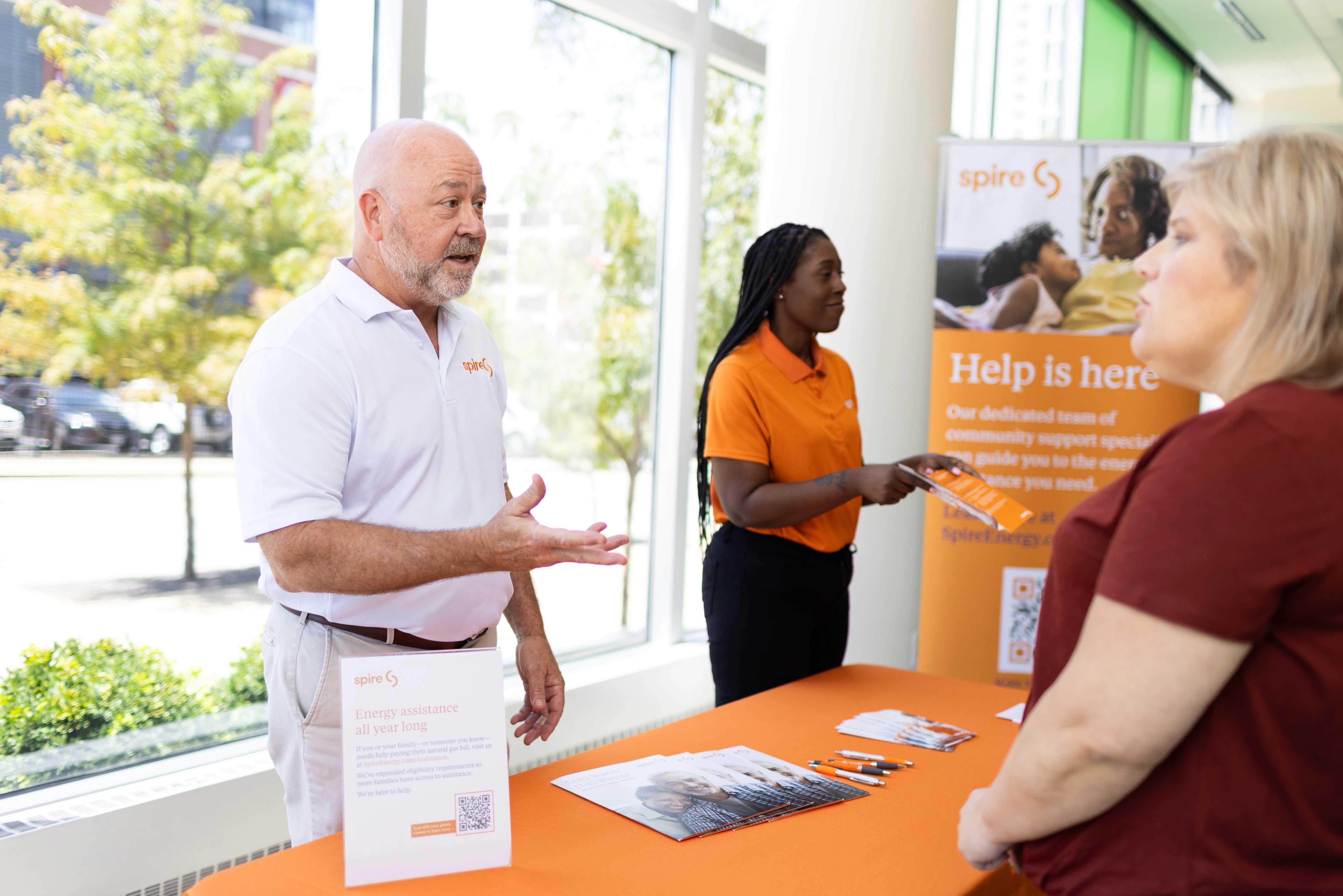 Image of a male Spire employee and female Spire employee helping a Spire customer get assistance with their bill