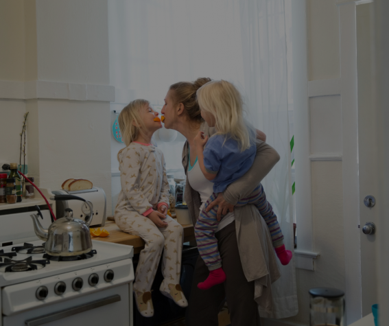 Image of: Family hugging in kitchen by stove