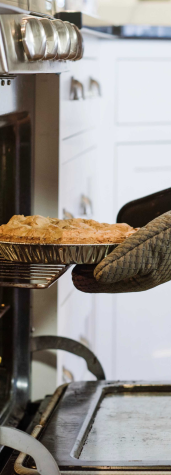 Image of woman pulling a pie out of the oven