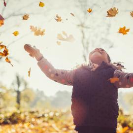 Child playing in leaves